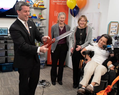 Joyous ribbon cutting ceremony with balloons and smiles.