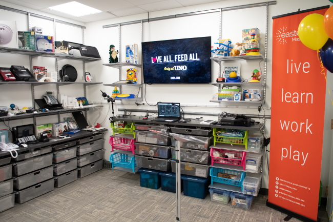 Equipment is displayed on open shelving and see-through drawers on two walls along with a wall-mounted TV.